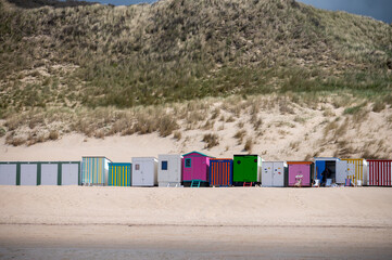 Obraz na płótnie Canvas Small beach huts on white sandy beach North sea beach near Zoutelande, Zeeland, Netherlands