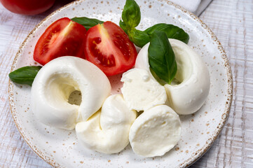 South Italian soft white mozzarella cheese made from buffalo cows milk served with ripe tomatoes and fresh green basil herb