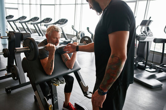 Coach with elder client in gym