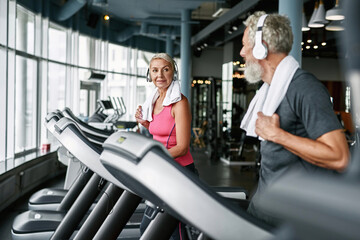 Sporty seniors exercising together in modern gym