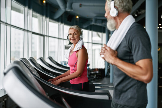 Living active life after retirement. Attractive senior woman on treadmill.