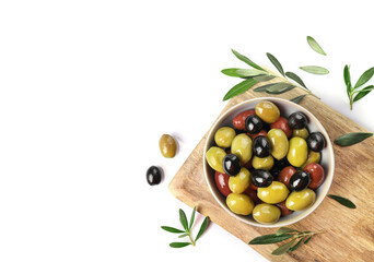 Green, red and black olives in bowl isolated on white background