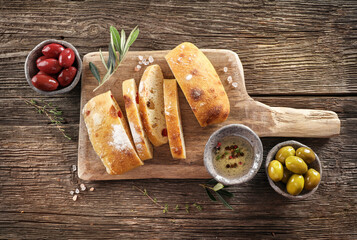 Virgin olive oil, olives and fresh bread on the table. Top view