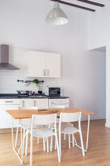 Interior spacious light dining room connected with kitchen in modern contemporary style