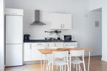 Interior spacious light dining room connected with kitchen in modern contemporary style