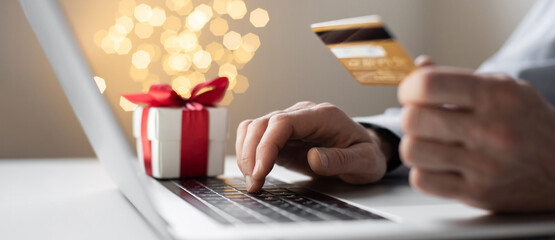 Man using laptop computer and credit card ordering Christmas gift panoramic banner, Shopping online...