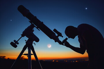 Silhouette of a man, telescope and countryside under the starry skies.