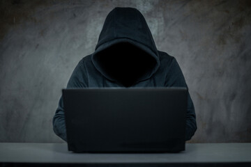 Hacker, hacker hacks network, hacker on a dark background. Dangerous Hooded Hacker Breaks into Government Data Servers