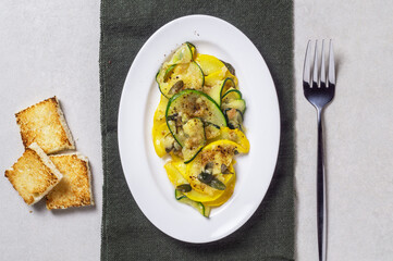 Fried zucchini with melted cheese and garlic in