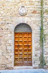 Vintage front door in the medieval city of Italy. Ancient wooden gate. Old city streets, beautiful doors and unusual door handles.