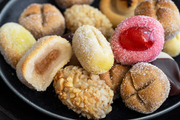 Panellets, different Catalan small cakes, served with sweet white wine . Typical sweets consumed at All Saints Day, Dia Todos Los Santos in Catalonia, Spain.