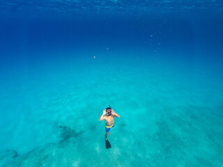 Underwater photo of man free diving in clear sea
