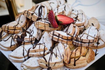 Fuente de buffet de galletas con sirope de chocolate, fresas y az&uacute;car en polvo