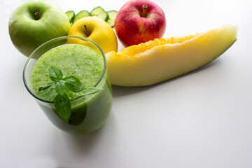 Batido de manzana, pepino, y melón,  saludable para el desayuno, acompañado de los ingredientes necesarios para prepararlo