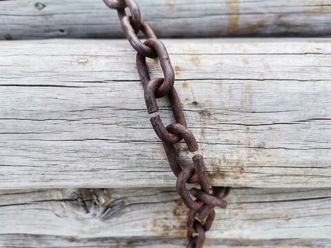 Chain on wooden floor. Moldy chain