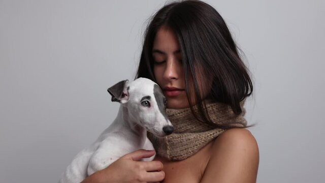 Woman posing and dancing in knitwear scarf holding dog