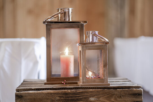 Two candle lanterns on a wooden table for a wedding decoration