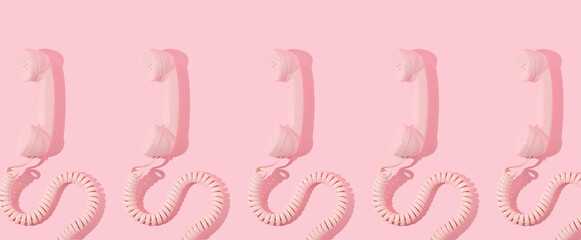 Pastel pink retro telephone handset creative pattern on pastel pink background. Vintage aesthetic 80s or 90s fashion background. Romantic communication idea.