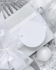 Christmas present with blank gift tag and white decorations, Mockup