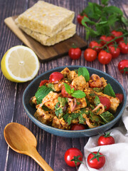 Healthy tempeh salad in spicy Thai style, mixed vegetables such cherry tomato, mint leaf, shallot in a bowl. Tempeh is  Javanese food made fermented soy bean. One of higher protein plant based source 