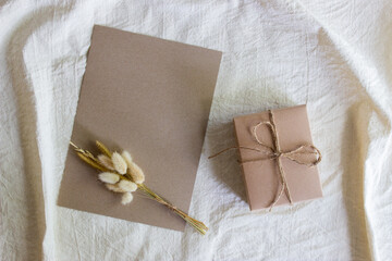 A gift box with letter and flowers on nature light.