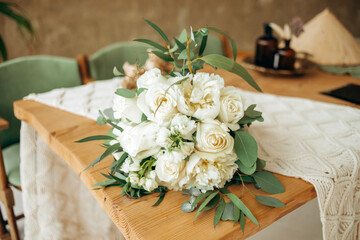 Beautiful white-green bouquet on a wooden table