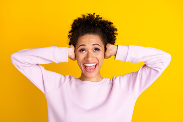 Portrait of annoyed irritated dark skin person arms cover ears look up empty space isolated on yellow color background