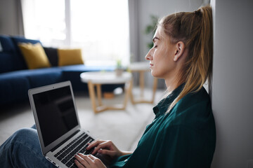 Obraz premium Tired young woman student with laptop at home, home office and learning.