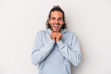 Young caucasian man isolated on gray background praying for luck, amazed and opening mouth looking to front.