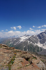 View from a brown stone ledge to a distant snowy peak