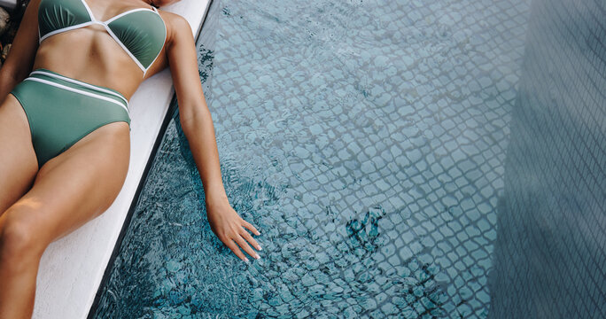 Female body lying next to a pool