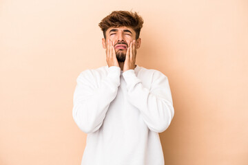 Young arab man isolated on beige background whining and crying disconsolately.