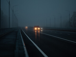 Foggy road. Cars are driving in the fog on the highway.