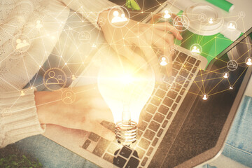 Double exposure of woman hands typing on computer and social network theme hologram drawing. People...