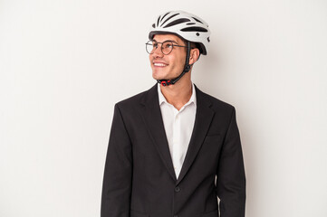 Young business caucasian man holding bike helmet isolated on white background dreaming of achieving goals and purposes