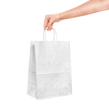 Female hand holding paper shopping bag isolated on white background. Black Friday sales concept. High quality photo mockup of packaging
