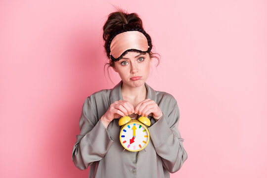 Photo of young girl unhappy upset hold clock time timer late morning isolated over pink color background