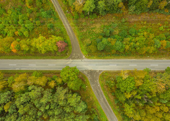 Skrzyżowanie drogi asfaltowej z drogą leśną. Widok z drona.