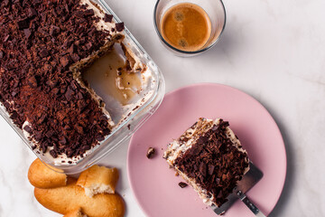 Top view of gourmet Tiramisu italian with a cup of coffee and a piece of cake served with copy space. Classic italian recipe.