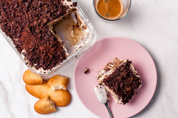 Top view of gourmet Tiramisu italian with a cup of coffee and a piece of cake served with copy space. Classic italian recipe.