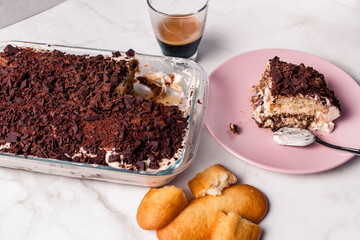 High angle view of gourmet Tiramisu italian with a cup of coffee and a piece of cake served with copy space. Classic italian recipe.