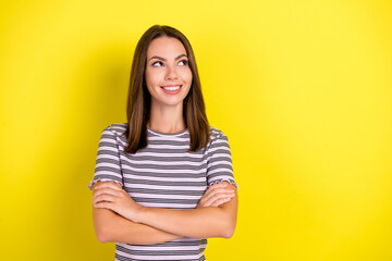 Obraz premium Photo of cool millennial brunette lady crossed arms look empty space wear striped t-shirt isolated on yellow background