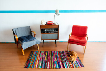 Vintage room with old fashioned armchair, retro radio turntable, telephone and standart lamp, cat...