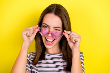 Photo of cute young brunette lady blink wear eyewear white t-shirt isolated on yellow background