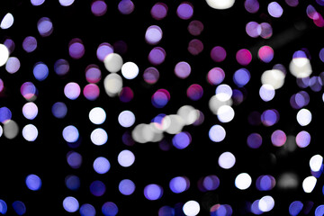 Christmas bokeh overlay background. Blue and violet light on the black background. New Year, festive atmosphere