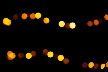 Christmas bokeh overlay background. Golden yellow and red garland light on the black background. New Year, festive atmosphere