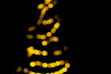Christmas bokeh overlay background. Golden christmas tree light on the black background. New Year, festive atmosphere