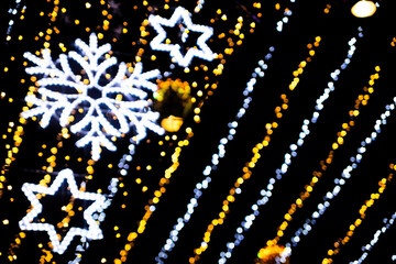 Christmas bokeh overlay background. colored garland light with snowflake on the black background. New Year, festive atmosphere