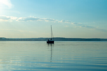 Obraz premium Beautiful water landscape with yacht and sail at sunset