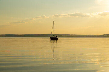 Beautiful water landscape with yacht and sail at sunset